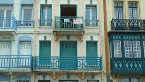 A multi-story building with balconies, a sign reading "LA-VAGUE", and a "A LOUER" rental sign.