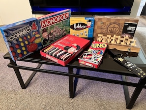 Une table sur laquelle on trouve divers jeux de société, notamment Connect 4, Monopoly, Yahtzee, UNO, ainsi qu’un jeu d’échecs.