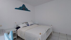 A bedroom with a bed, nightstand, and a decorative wall piece. - Medina town house (Sousse)