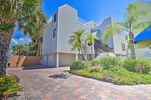 A modern building with a flat roof and a brick pathway leading to the entrance. - Coastal Surfside Swank by Beachside Management (Siesta Key)