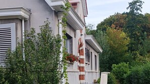 A two-story house with a red-tiled roof, a brick chimney, and a stone pathway leading to the entrance. - Pearl in the heart of Bruges (Brugge)