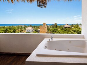 A bathroom with a large bathtub, a view of the ocean, and tropical vegetation. - PUNTA KAI  (Puerto Escondido)
