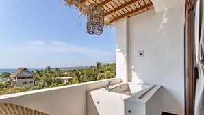 A balcony with a built-in sink and a view of the ocean and palm trees. - PUNTA KAI  (Puerto Escondido)