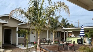 Un patio con terraza de madera, mobiliario exterior y una pequeña piscina.