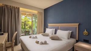 Une chambre d’hôtel avec un grand lit, un bureau et une vue sur l’extérieur.
