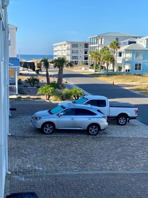 A white car and a white pickup truck parked on a paved driveway. - Set Sail 7 - Spacious Townhome 3 Bed/2.5 bath/sleeps7 - 1 min walk to the beach! (Mexico beach)