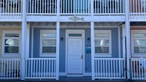 A two-story building with a white exterior, a central door, and a balcony on each floor. - Set Sail 7 - Spacious Townhome 3 Bed/2.5 bath/sleeps7 - 1 min walk to the beach! (Mexico beach)