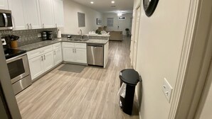 A modern kitchen with white cabinets, a stainless steel dishwasher, and a granite countertop. - Set Sail 7 - Spacious Townhome 3 Bed/2.5 bath/sleeps7 - 1 min walk to the beach! (Mexico beach)