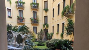 Un patio con plantas en macetas y suelo de baldosas.