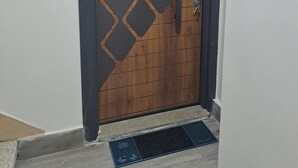 Eine Holztür mit einem geometrischen Muster, einem Metallgriff und einem Schlüsselloch.