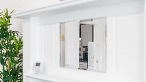 Ein modernes, weißes Interieur mit einer Tür, die in einen Küchenbereich führt.