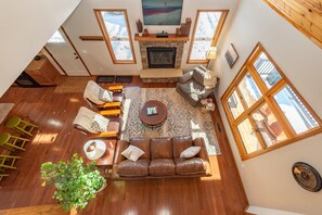 A spacious living area with a fireplace, a large window, and a cozy seating arrangement.