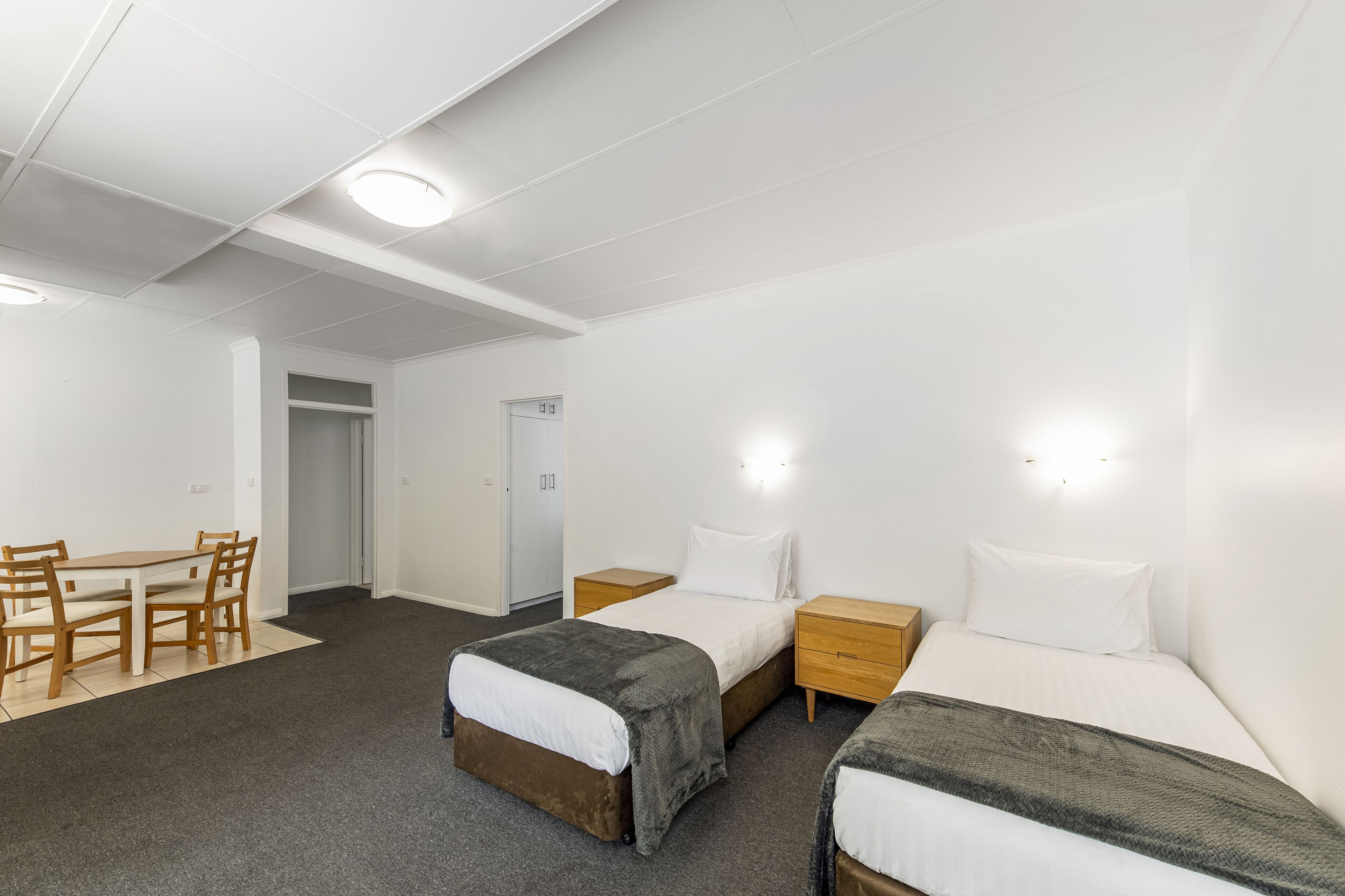Een hotelkamer met twee bedden, een bureau en een stoel.