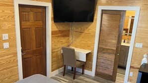 A bedroom with a bed, a desk, a chair, a television, and a ceiling fan. - Old Town Key West Cottage 3bed/2bath (Key West)