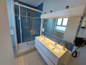Habitación triple, varias camas | Baño | Regadera, amenidades de baño gratuitas, secadora de cabello, toallas