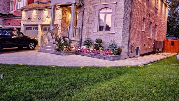 A two-story house with a stone facade, a front porch, and a driveway. - Adorable 2 bedrooms, 2 washrooms, 2 parking spots apartment (Newmarket)