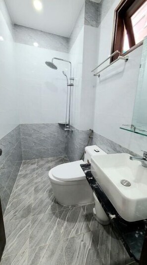 Un bany amb vàter, un lavabo i una dutxa.