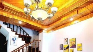 A spacious living area with a wooden ceiling, a staircase, a sofa set, and a coffee table with a plant. - Entire Home: Beautiful, Brand-new built in 2022 (Phuong 6, Da Lat city)