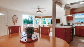 A modern kitchen with a central island, wooden chairs, and a dining table. - Ocean view! Walk to Sunset Cliffs - Surf - Beach! (San Diego)