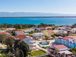 Uma área residencial à beira-mar, com casas, piscina e vista para o oceano.