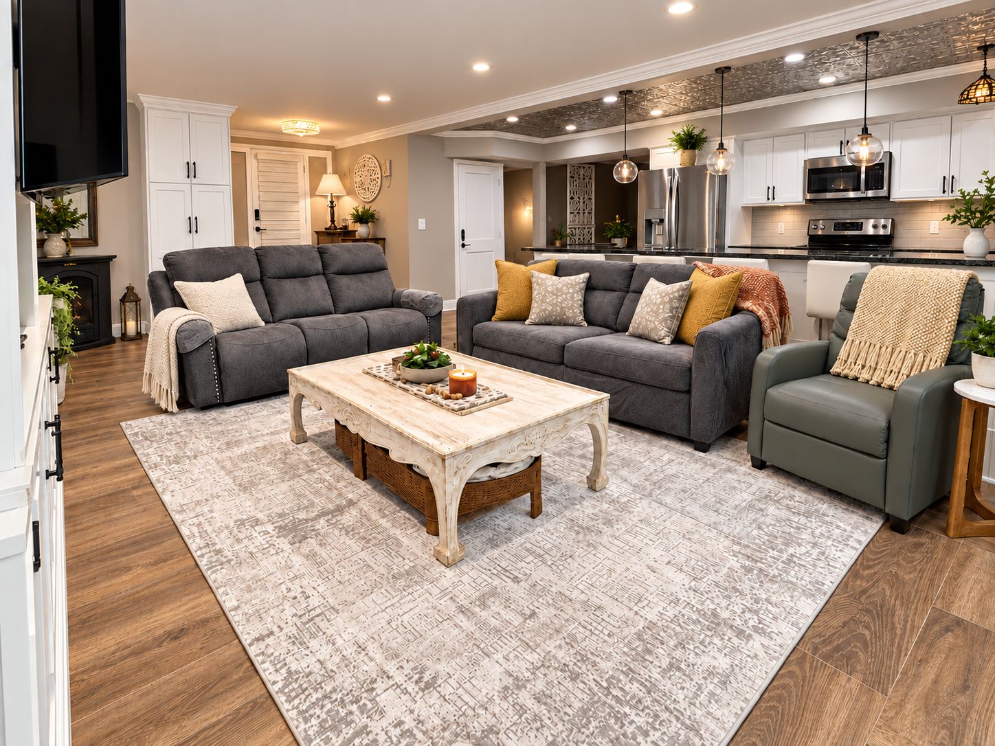 A modern living room with a fireplace, sofas, a coffee table, and a kitchen area with appliances.