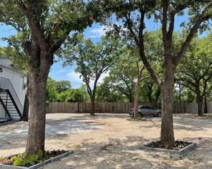 Stroll through the serene outdoor space surrounded by mature trees and an entrance.