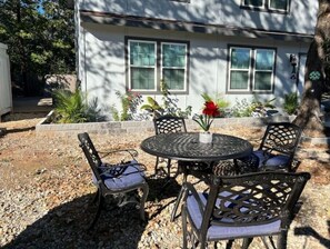 Relax in this serene outdoor seating area with a round table and four comfortable chairs.