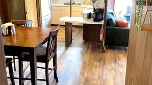 A compact living space with a dining area, kitchenette, and seating area.