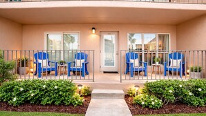 A two-story building with a balcony, blue chairs, and a door marked '206'. - Beach View Condo 106 By The Beach  Heated Pool Hot tub (South Padre Island)