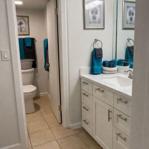 Une salle de bain avec des toilettes, un lavabo et des placards.