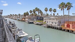 A waterfront property with docked boats, a marina, and a row of houses with balconies overlooking the water.