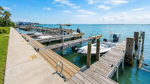Un puerto deportivo con muelles de madera, barcos y un cielo azul despejado.