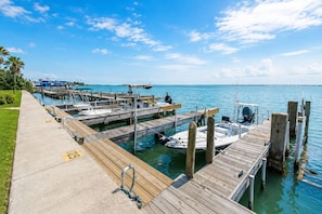 A marina with wooden docks, boats, and a clear blue sky. - Bayfront La Solana 126 Pool & Boat Slip (South Padre Island)