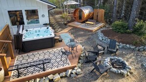 Banheira de hidromassagem, deck, área de estar externa e um espaço com lareira.