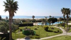 Ein Resort mit Pool, Palmen und Meerblick.