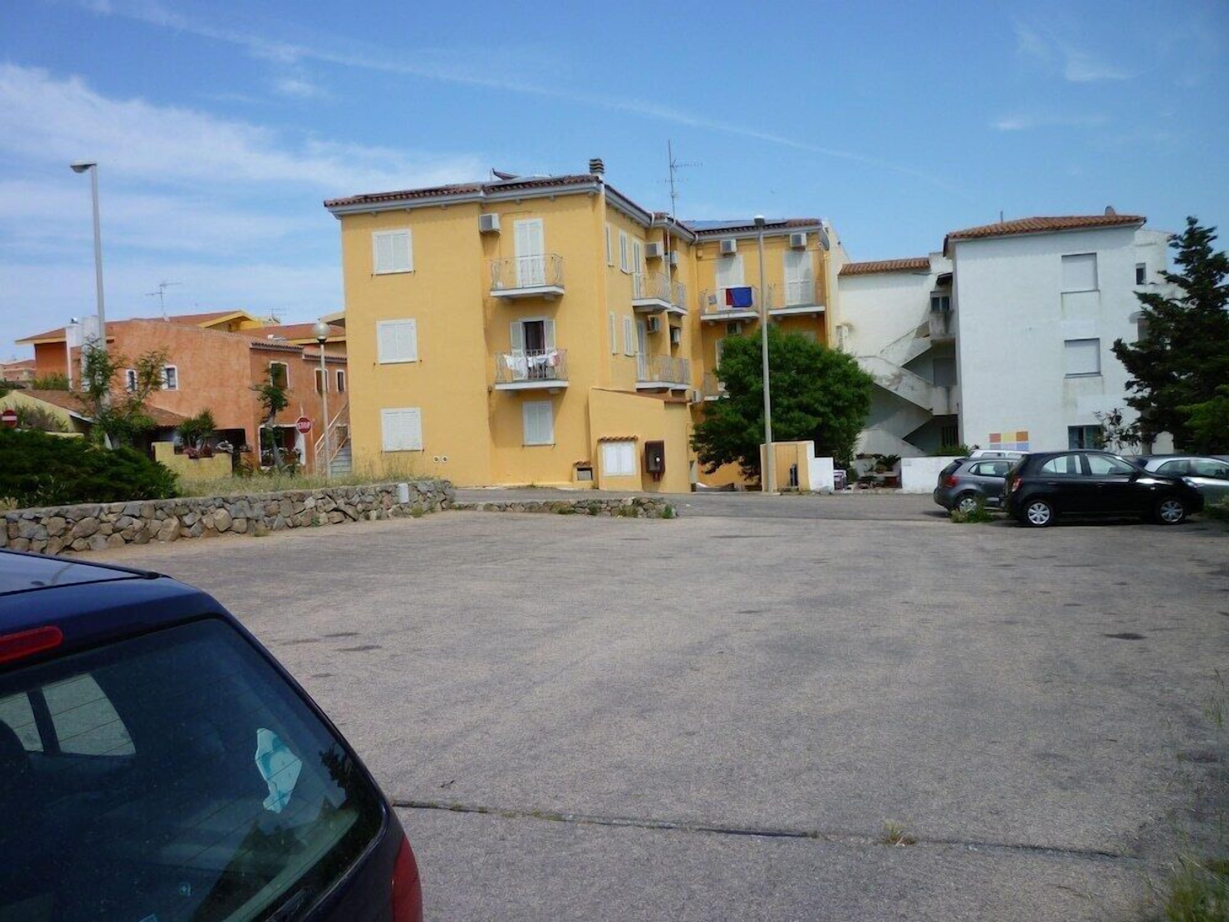 A parking lot with a yellow building in the background.