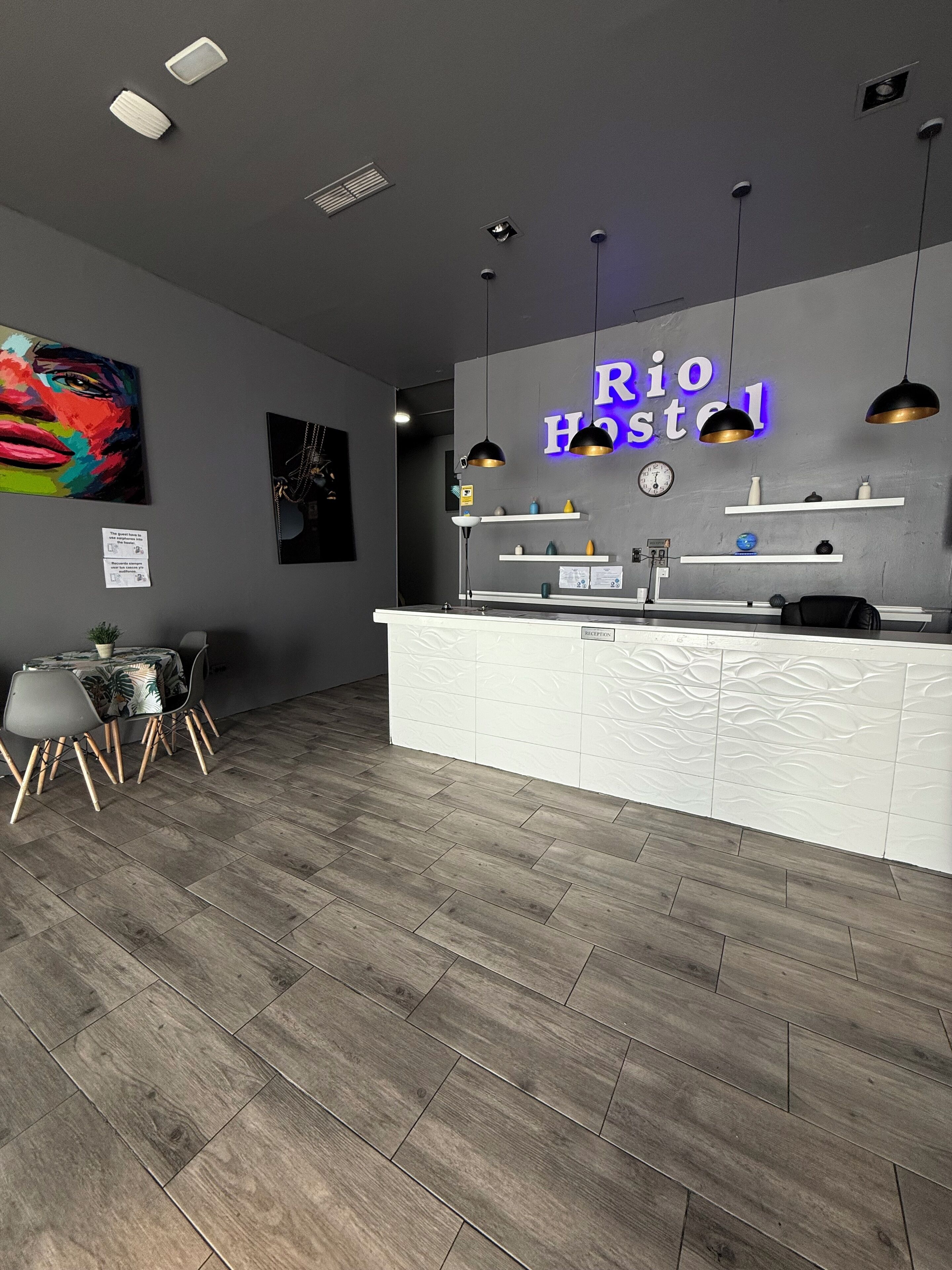 Una moderna recepción con un letrero de neón que dice "Rio Hostel".