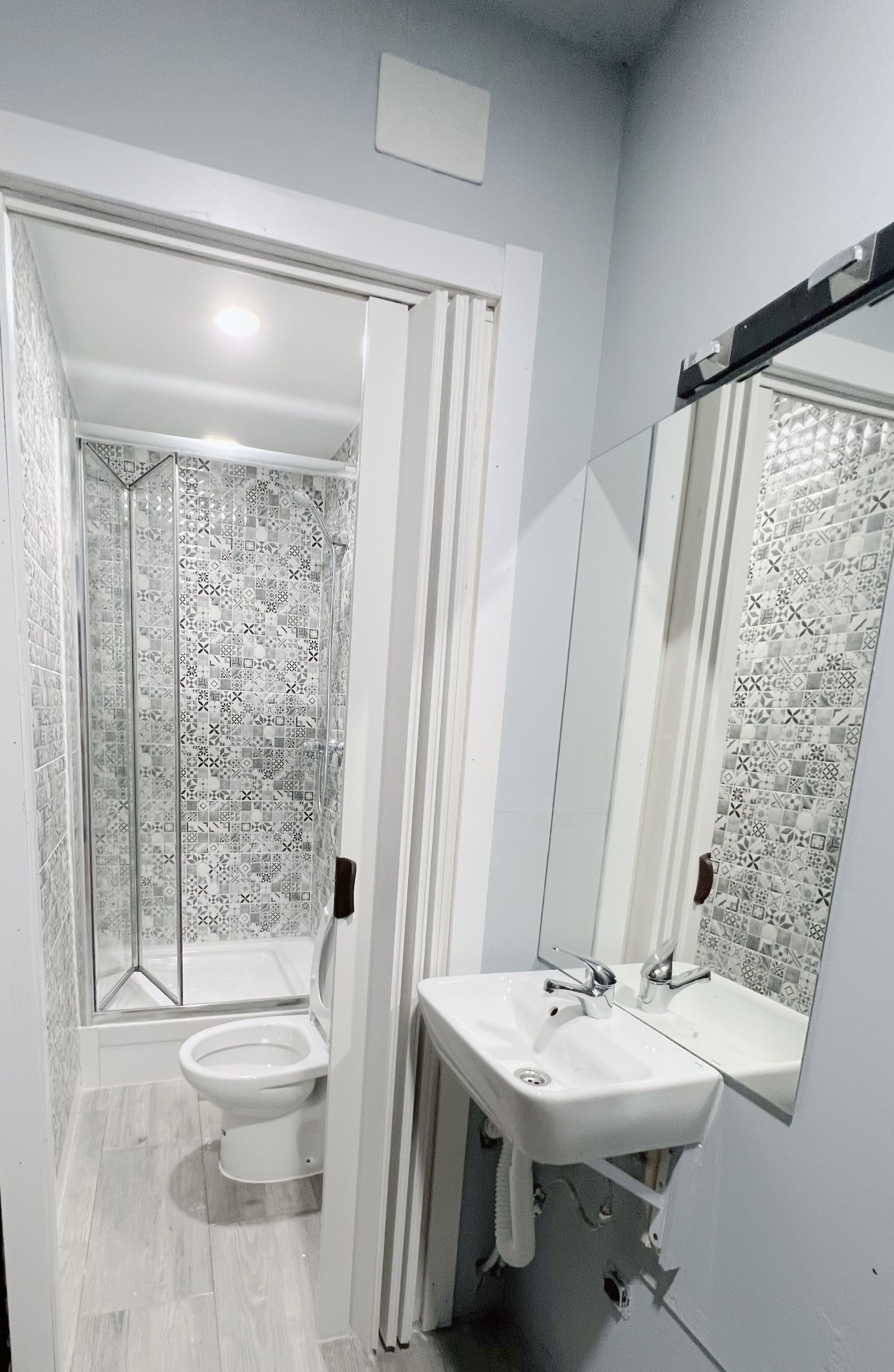 A bathroom with a shower, toilet, and sink.