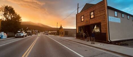 A street view with a building labeled "Treeline Hostel" on the right, featuring a wooden facade and a signboard.