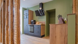 Una cocina moderna con horno empotrado, cafetera y encimera de madera.