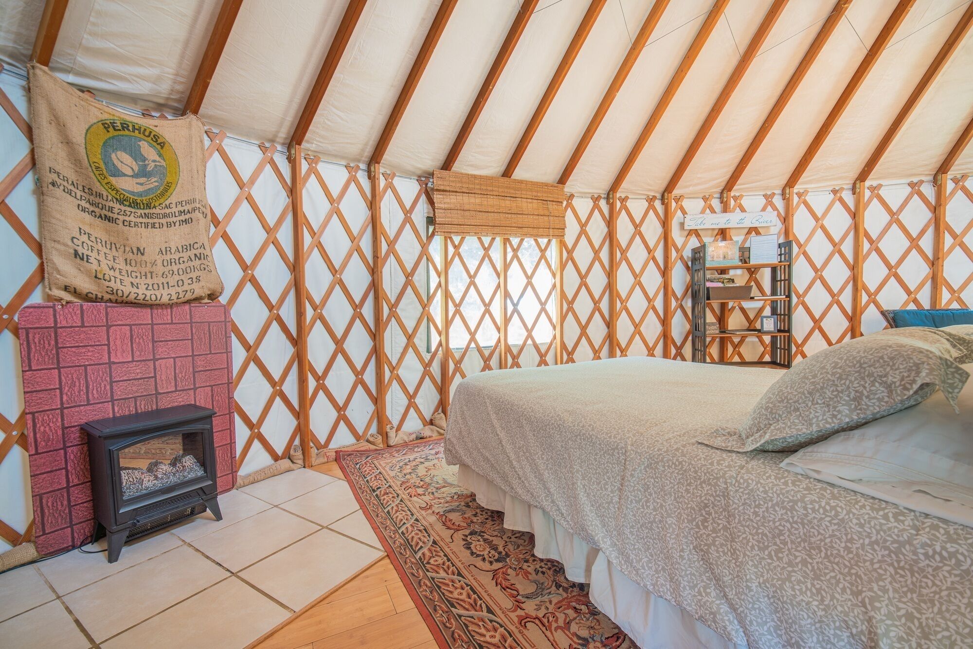 Ein gemütliches Zimmer mit einem Bett, einem kleinen Kamin und einem dekorativen Teppich.