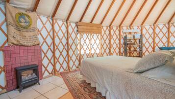 Ein gemütliches Zimmer mit einem Bett, einem kleinen Kamin und einem dekorativen Teppich.