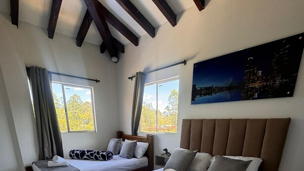 Une chambre d’hôtel avec deux lits, une vue sur la ville et un design moderne.