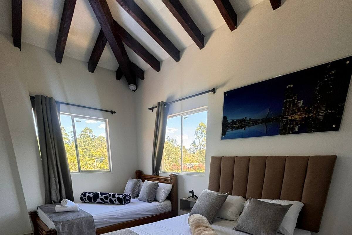 Une chambre d’hôtel avec deux lits, une vue sur la ville et un design moderne.