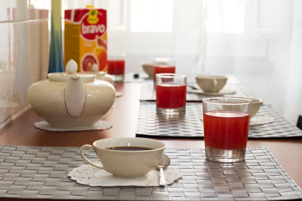 A kitchen with a teapot, cups, and a box of Brava juice.