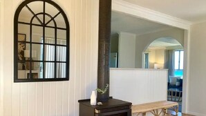 A cozy room with a black wood-burning stove, a woven basket, and a bench.