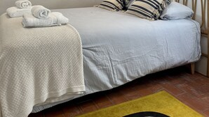 A bedroom with a bed, a headboard, and wall decor.