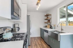 A modern kitchen with stainless steel appliances, a gas stove, and a dishwasher. - Audrey's Place, New Hot Tub, Mins to Joshua Tree (Joshua Tree)