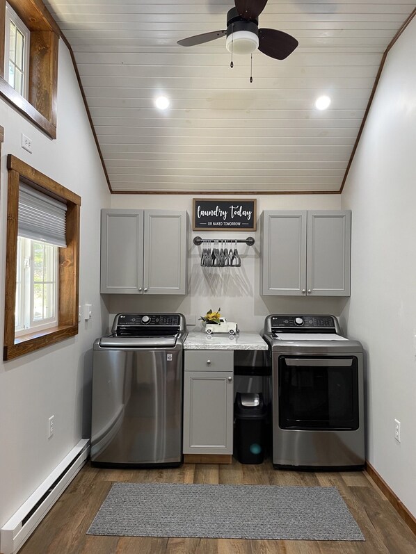 Cocina compacta con ventilador de techo, electrodomésticos integrados y zona de lavandería.