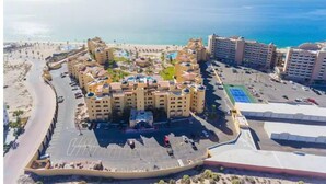 A resort with multiple buildings, a beach, and a parking area.